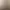 Moderne Badezimmer mit einem rechteckigen Waschbecken, einem runden Spiegel und einer Handbrause an einer gefliesten Wand